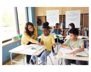Arts and Letters Teacher Working With Students in Classroom