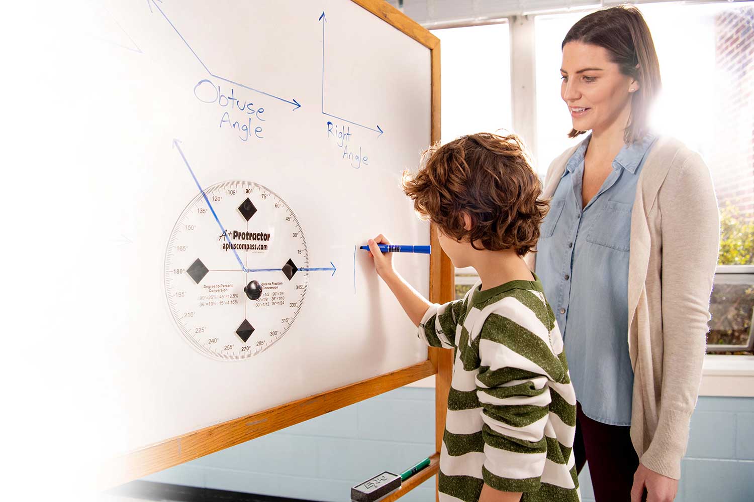 Student uses large protractor at a whiteboard to demonstrate understanding of obtuse and right angles.