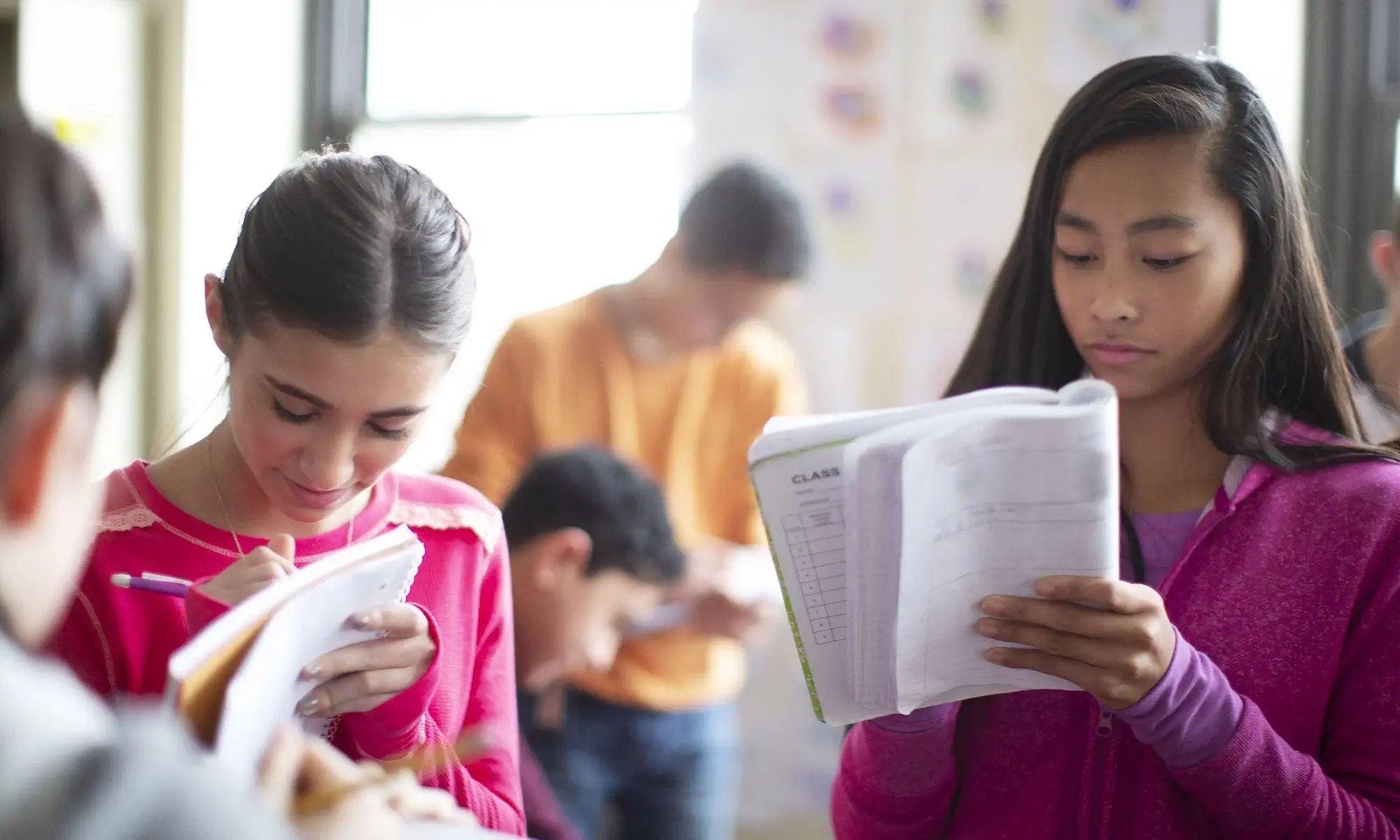 young student writing in notebook